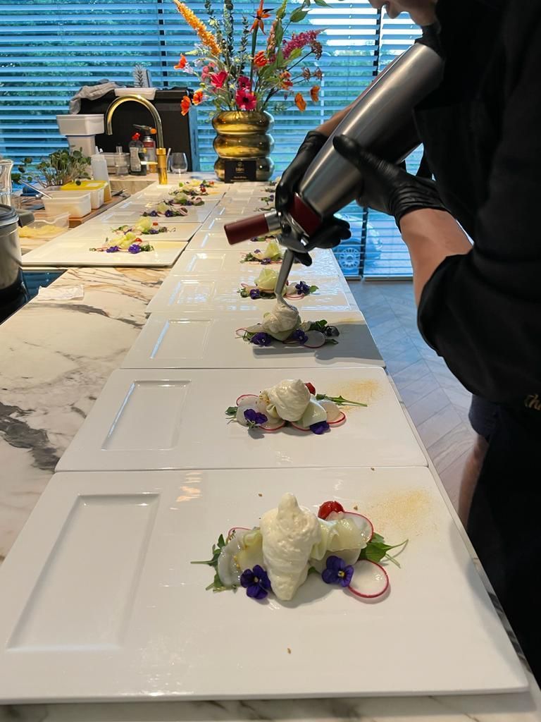 Op een lange buffettafel staan gastronomische gerechten op borden