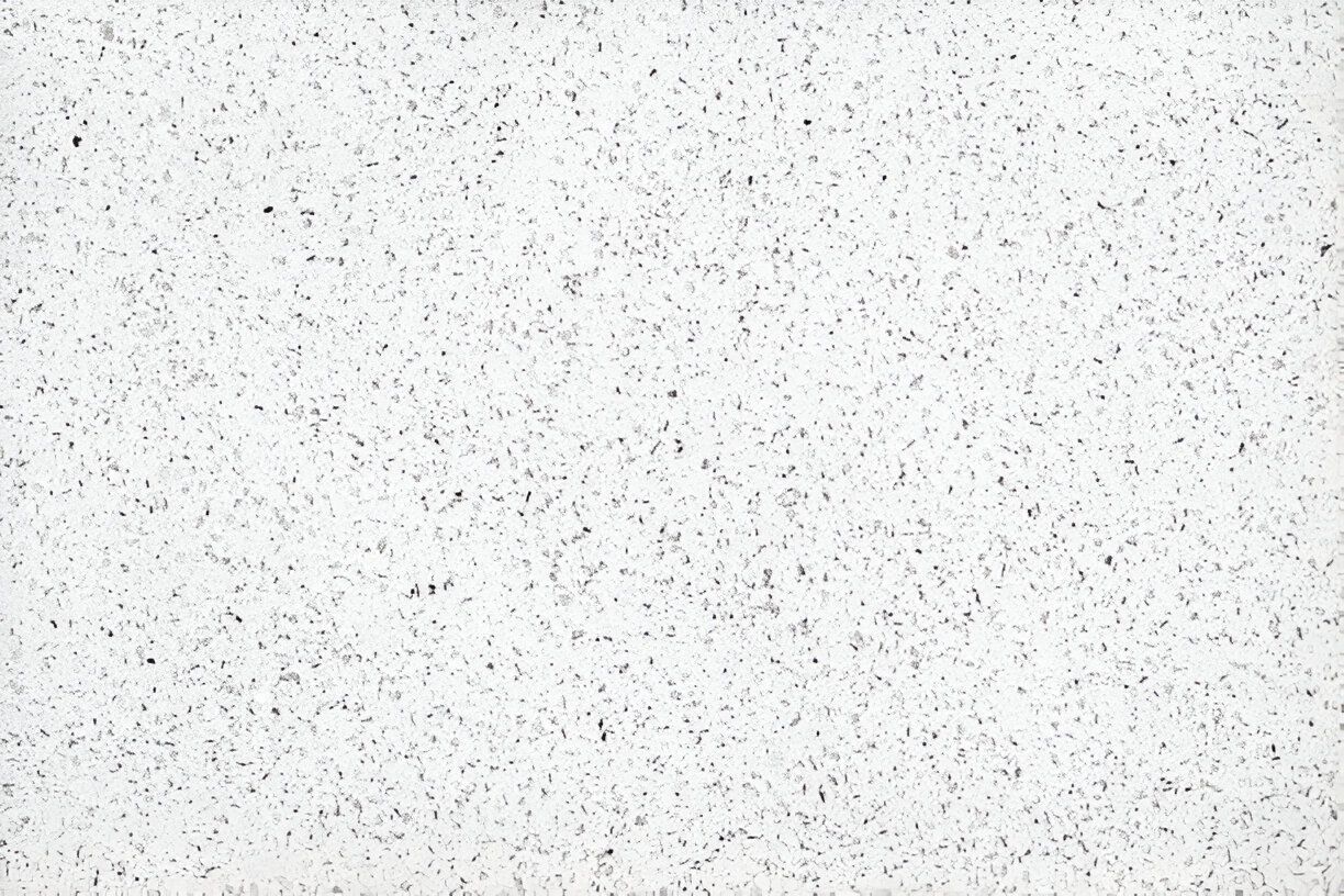 A close up of a white surface with small black dots on it.