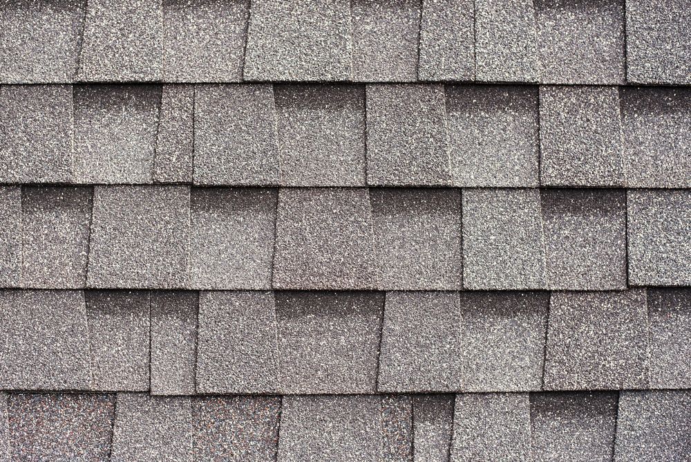 A close up of a row of gray shingles on a roof.