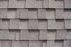 A close up of a row of gray shingles on a roof.