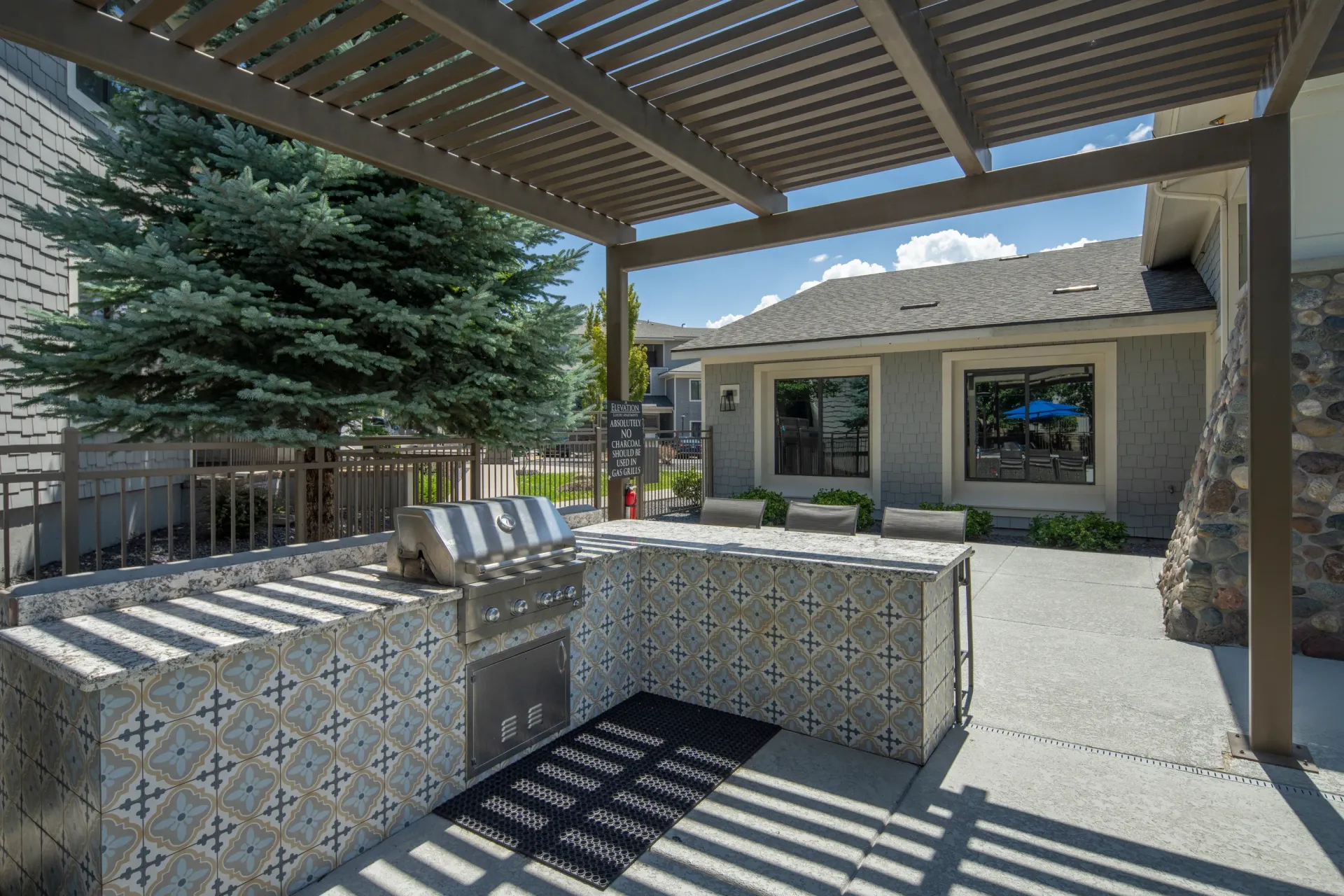 Outdoor kitchen with grill and counter space under a pergola at Elevation in Flagstaff, AZ.