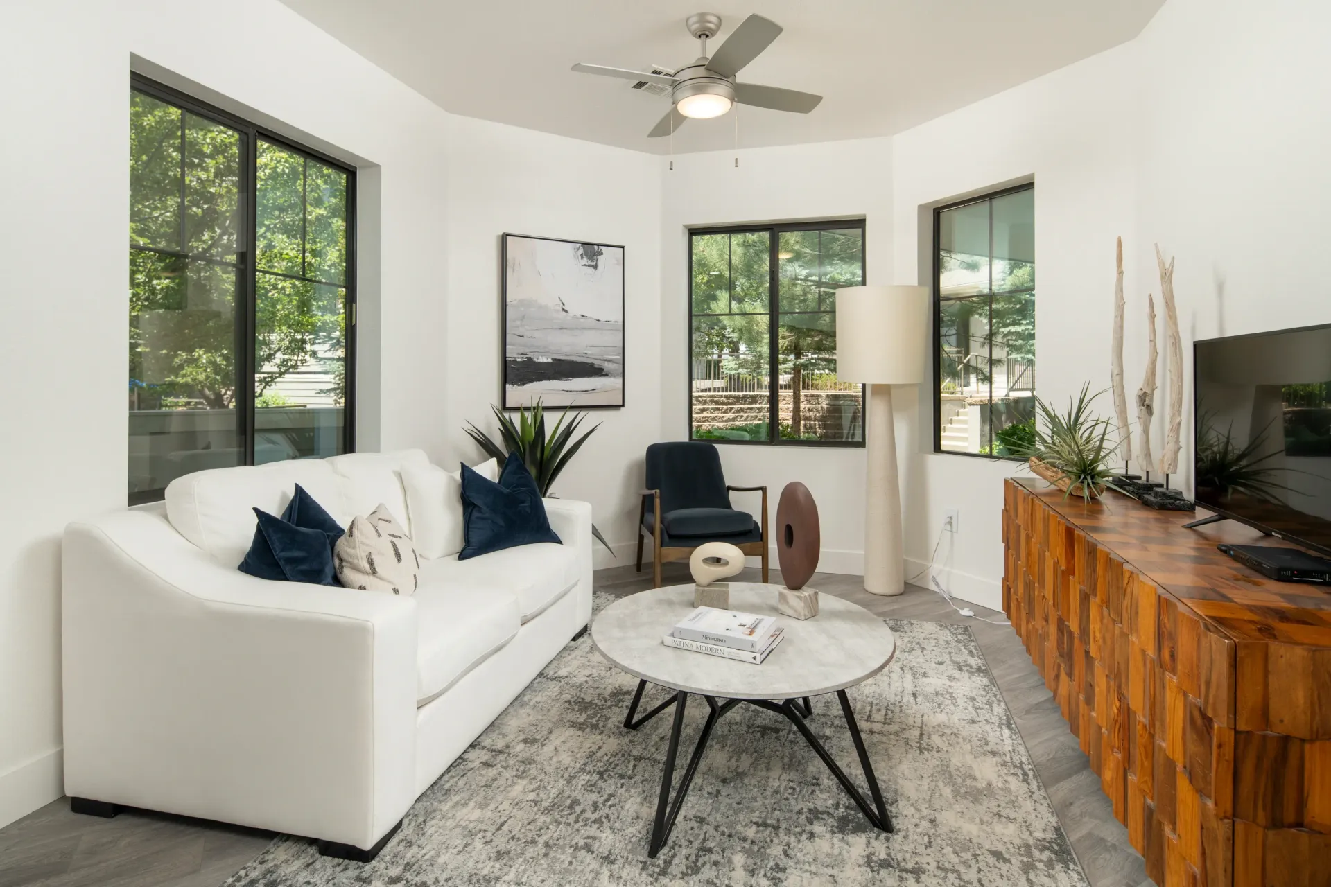Living room with white sofa, coffee table, and TV at Elevation in Flagstaff, AZ.