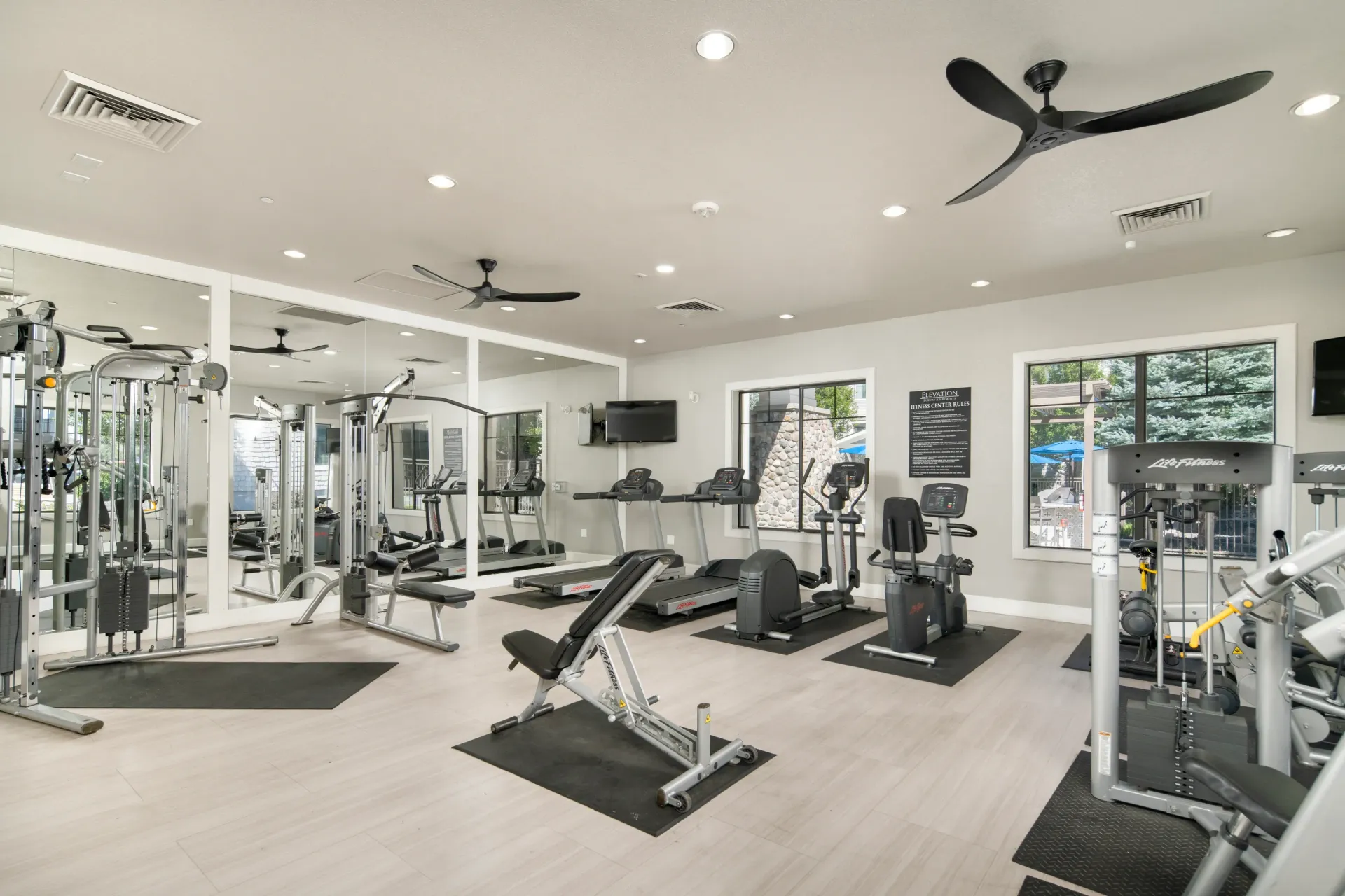 Fitness center with treadmills, elliptical machines, weight machines, and exercise bikes.