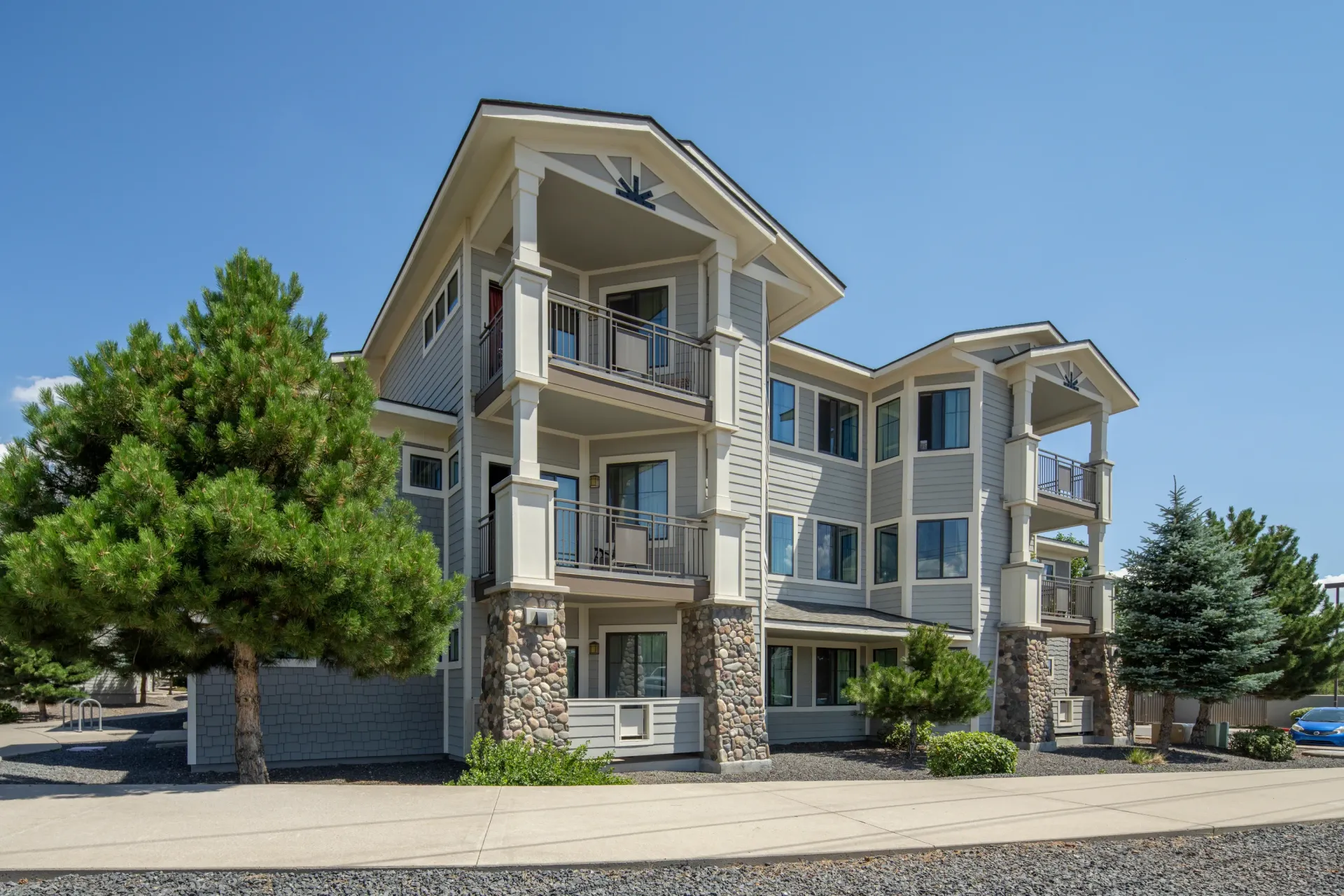 Exterior view of a multi-story apartment building with balconies and stone accents at Elevation in Flagstaff, AZ.