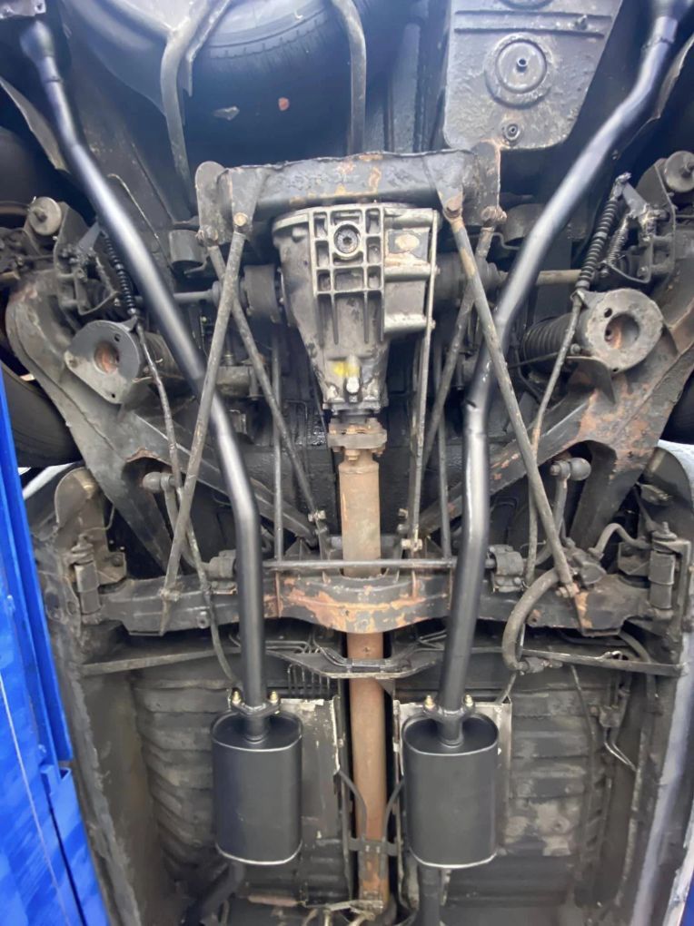 The underside of a car with exhaust pipes attached to it.