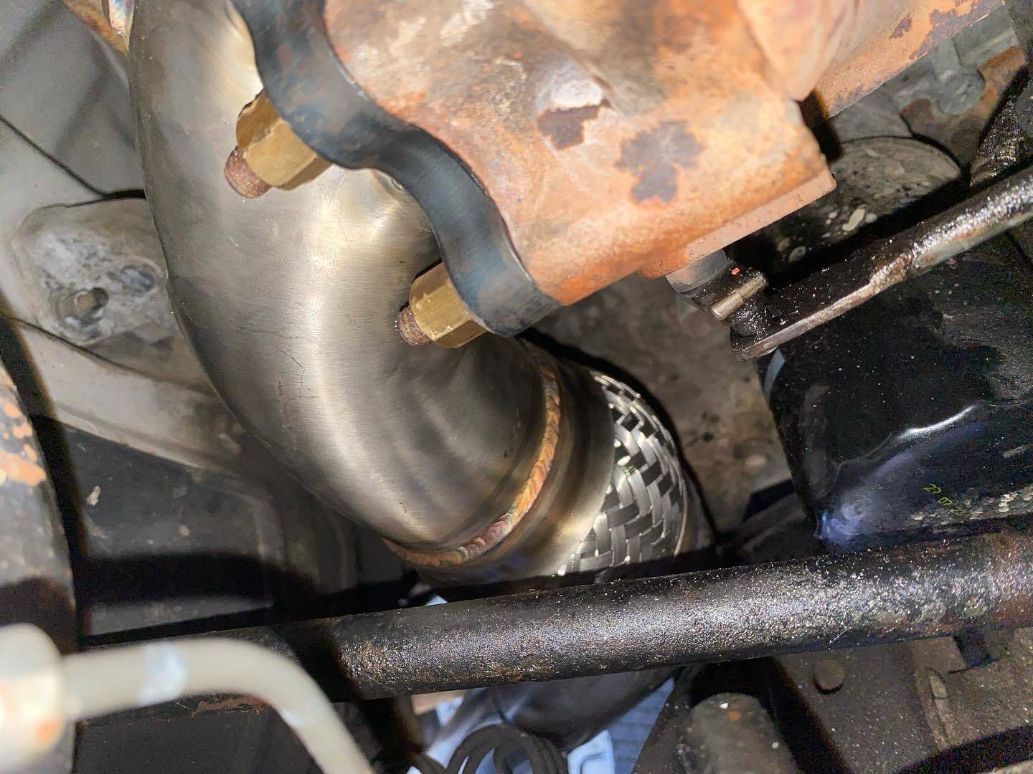 A Close Up of a Exhaust Pipe on a Car Engine — Savins Radiator Service In Lismore, NSW