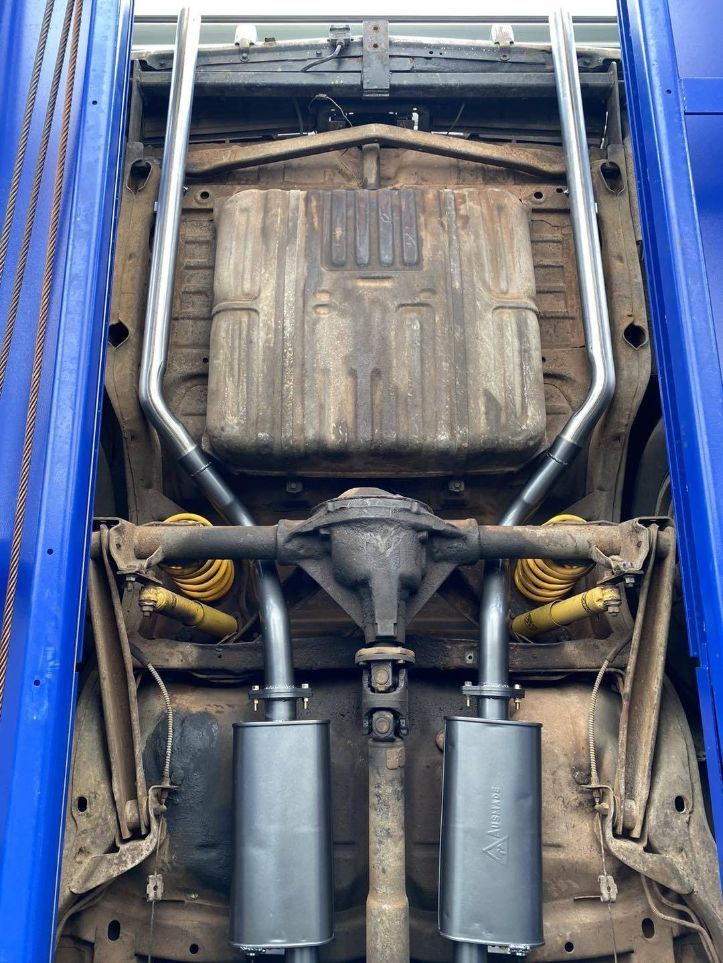 The Underside of a Car is Shown in a Garage With Exhaust Pipes — Savins Radiator Service In Lismore, NSW