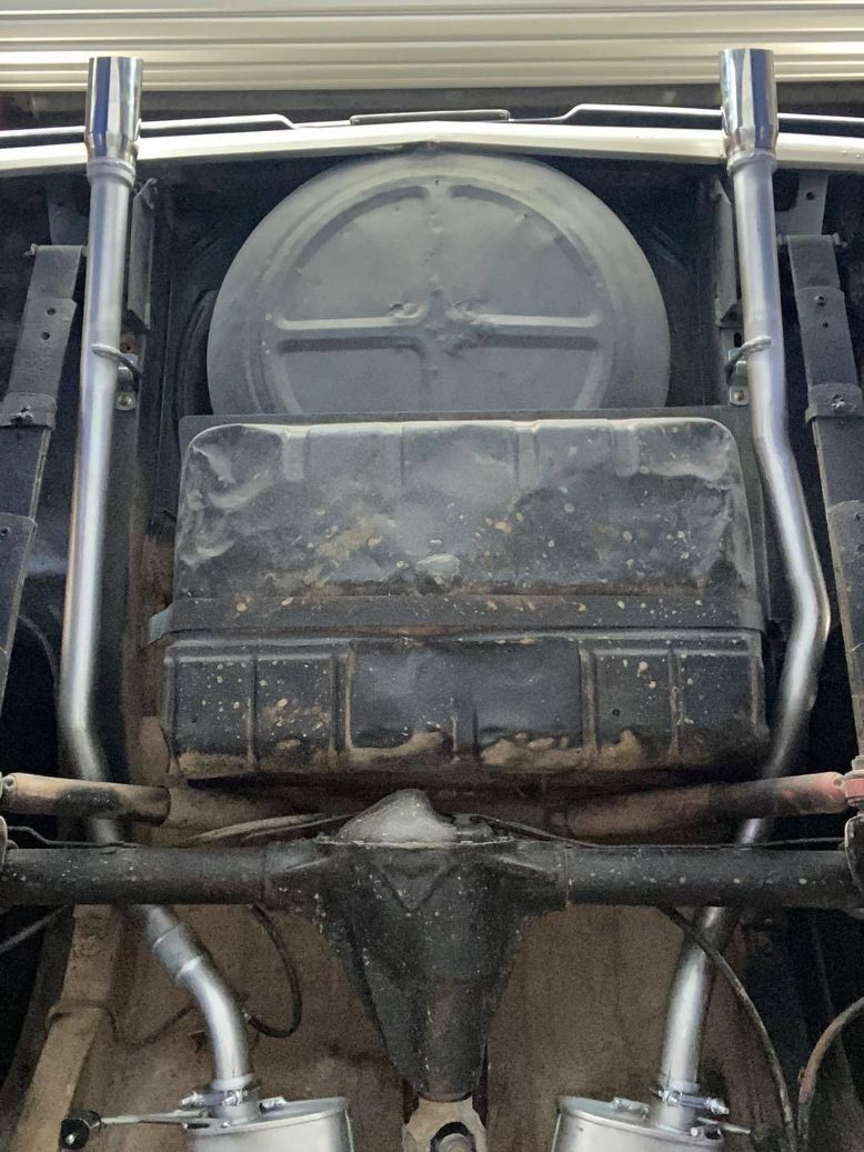 A Close Up of the Underside of a Car With Exhaust Pipes and a Tire — Savins Radiator Service In Lismore, NSW