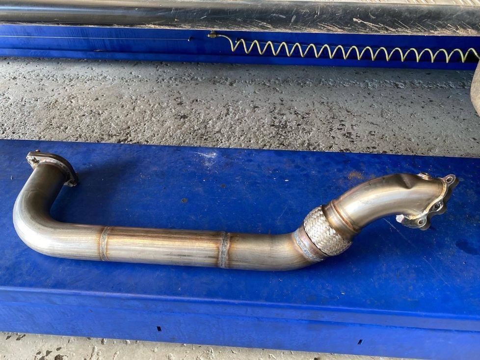A Stainless Steel Pipe is Sitting on a Blue Surface — Savins Radiator Service In Lismore, NSW