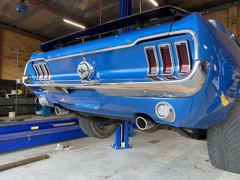 A Blue Mustang is Parked on a Lift in a Garage — Savins Radiator Service In Lismore, NSW