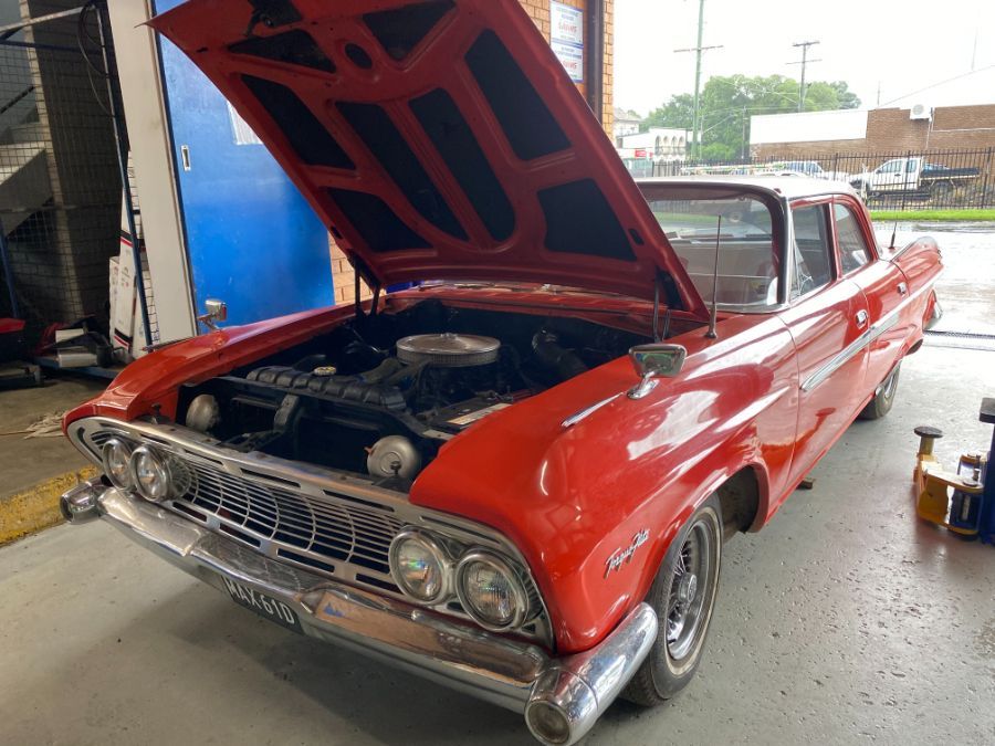 A Red Car With the Hood Up is Parked in a Garage — Savins Radiator Service In Lismore, NSW