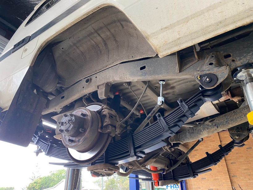A Car is Sitting on a Lift in a Garage — Savins Radiator Service In Lismore, NSW