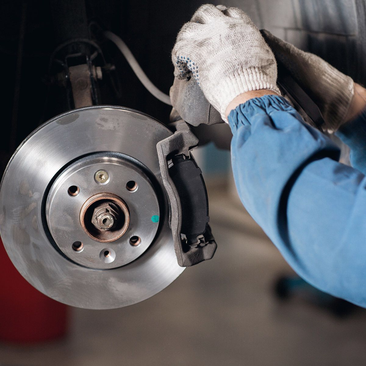 A Person is Working on a Brake Disc on a Car — Savins Radiator Service In Lismore, NSW