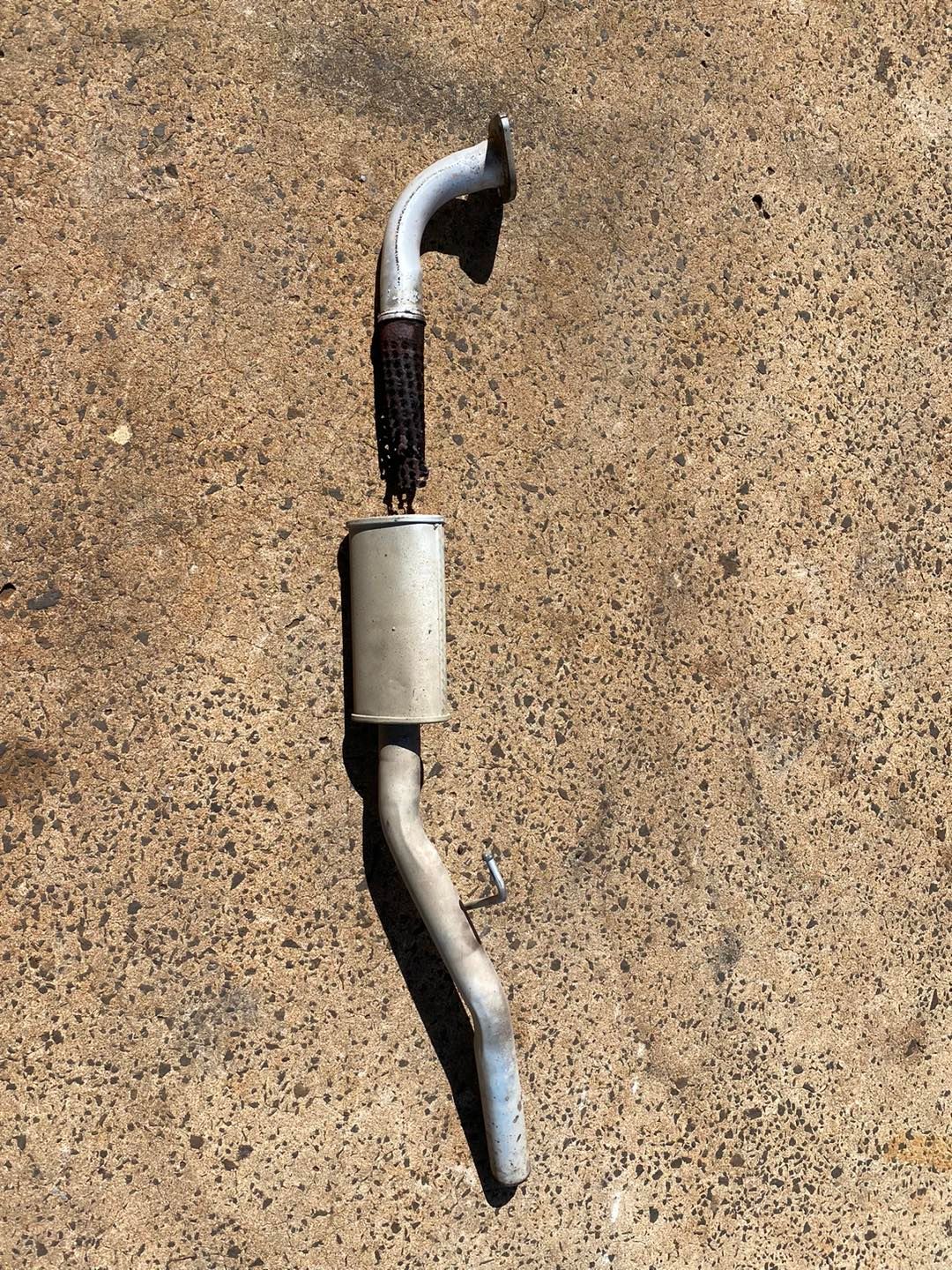 A Exhaust Pipe is Sitting on a Concrete Surface — Savins Radiator Service In Lismore, NSW