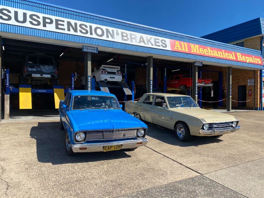 Two Old Cars Are Parked in Front of a Garage — Savins Radiator Service In Lismore, NSW