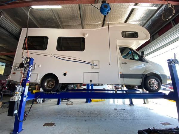 A Motorhomes is Sitting on a Lift in a Garage — Savins Radiator Service In Lismore, NSW