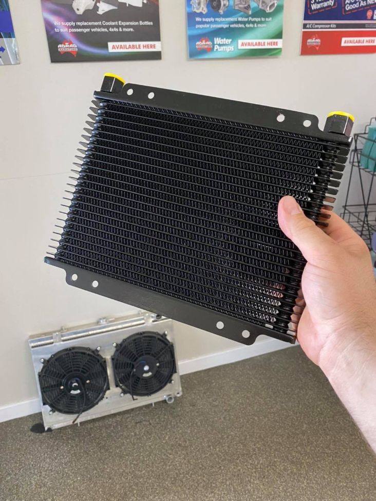 A Person is Holding a Radiator in Their Hand in a Room — Savins Radiator Service In Lismore, NSW
