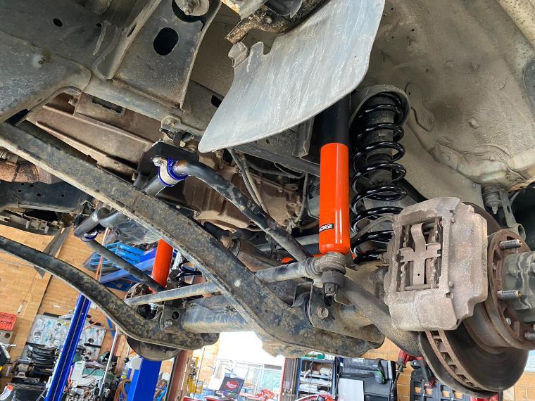 A Car is Sitting on a Lift in a Garage  — Savins Radiator Service In Grafton, NSW