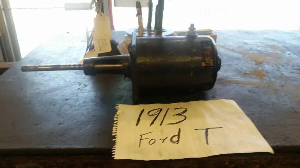 Black motor on a table with a handwritten note reading “1913 Ford T”