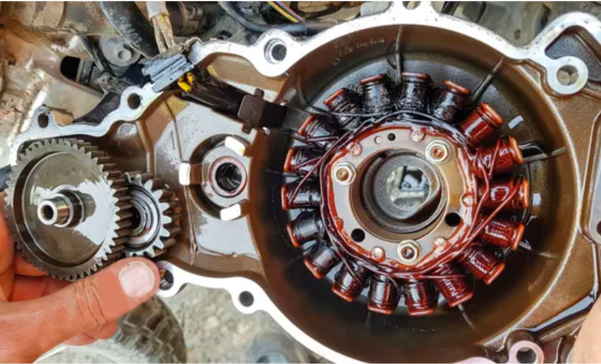 Close-up of an engine stator and gears inside a motorcycle engine casing