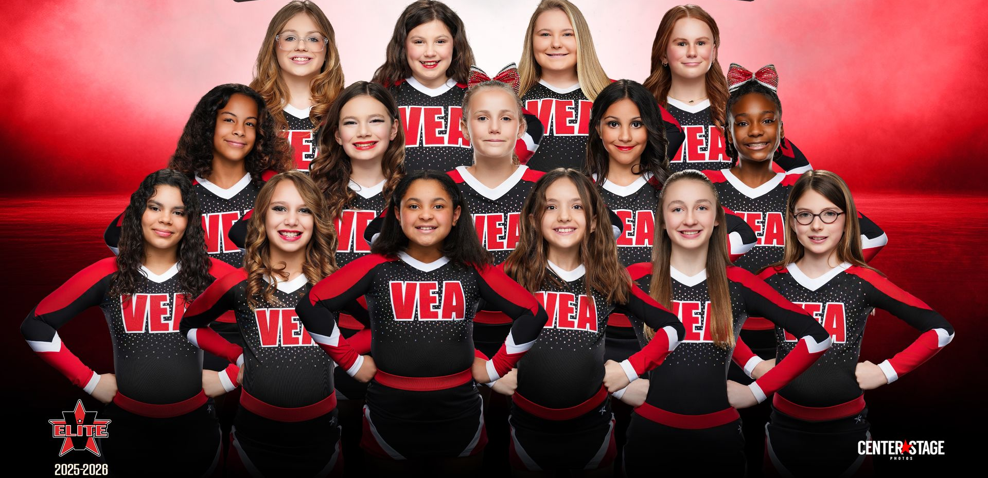 A group of fifteen cheerleaders posing in red and black uniforms against a bright red gradient background.