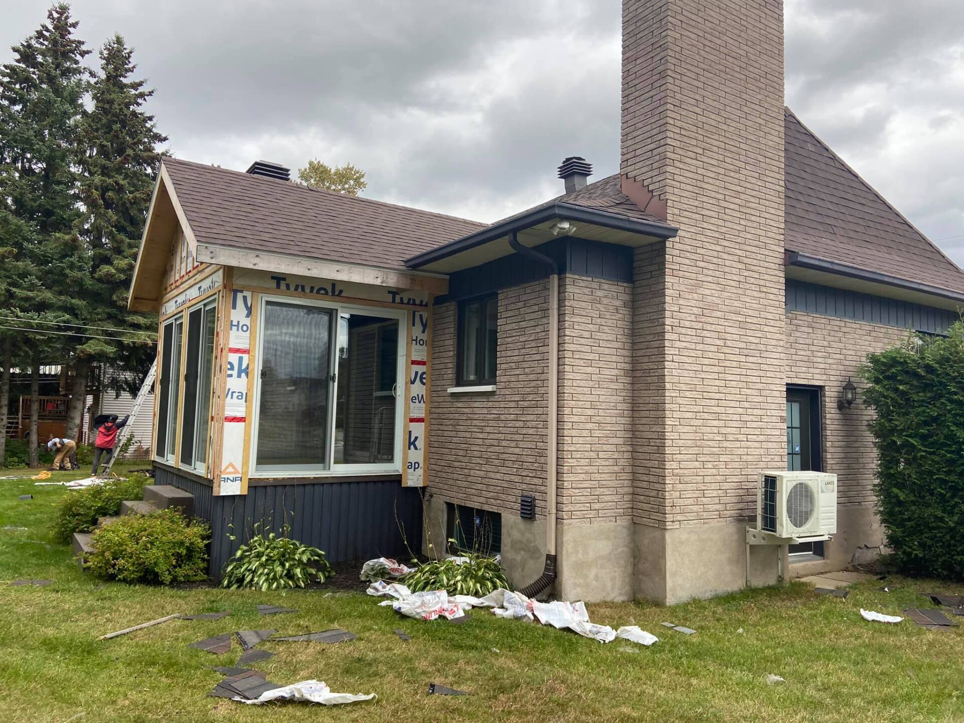 Une maison en brique avec une cheminée est en cours de rénovation.