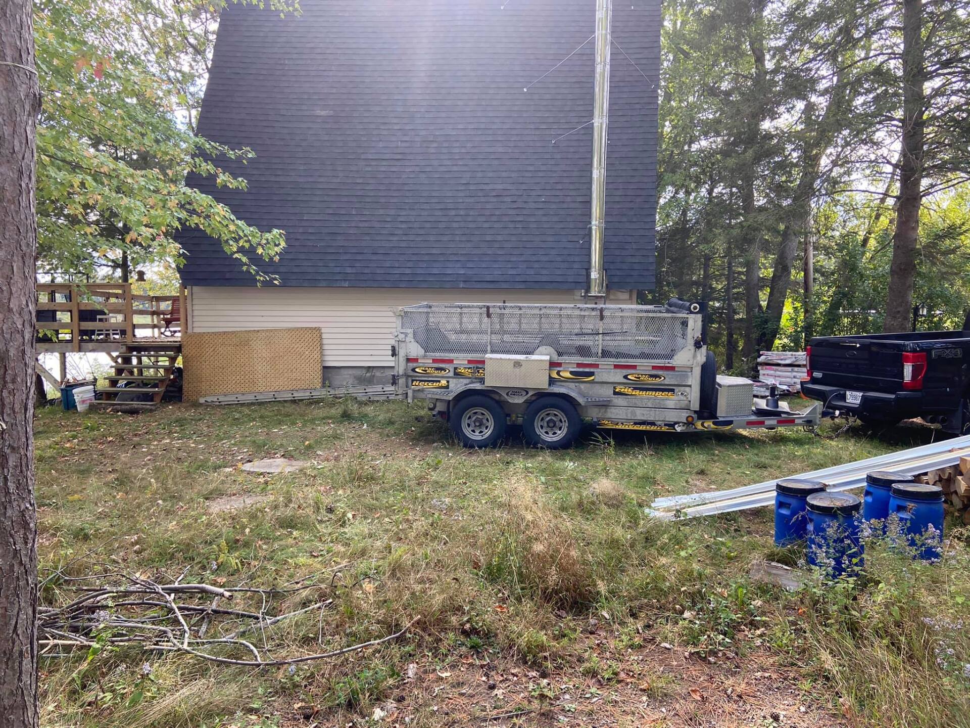 Une caravane est garée devant une maison dans une cour.