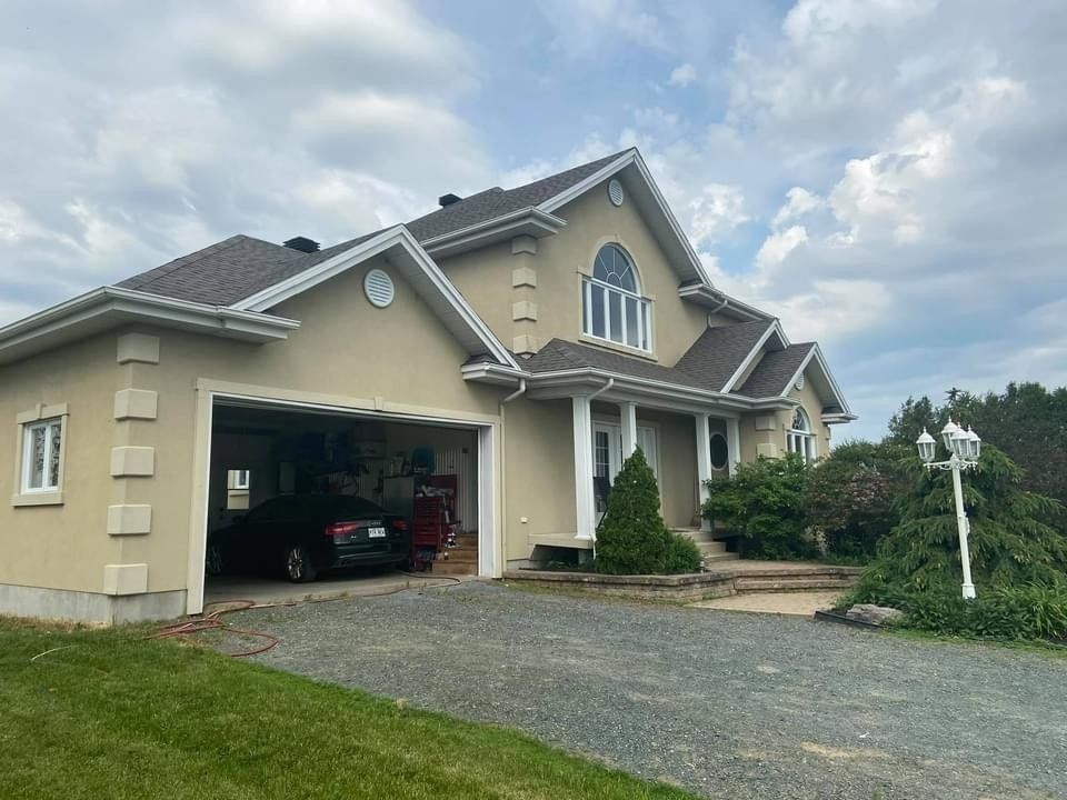 Une grande maison avec une voiture garée dans le garage.