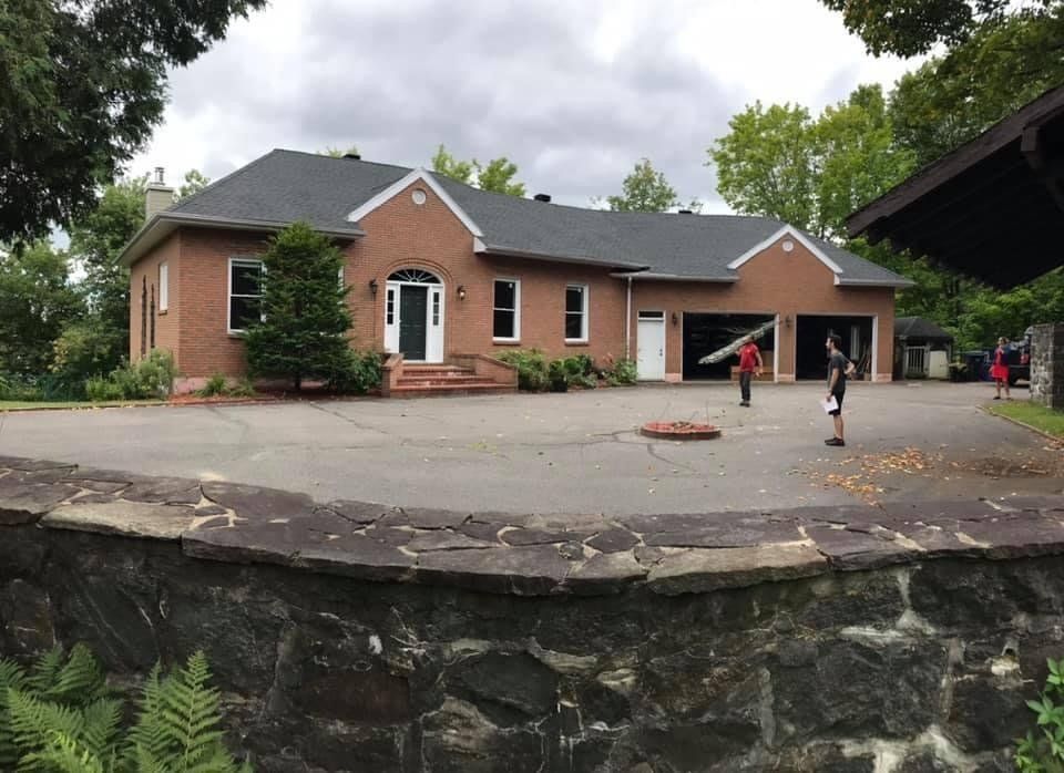 Une grande maison en brique avec un mur de pierre devant