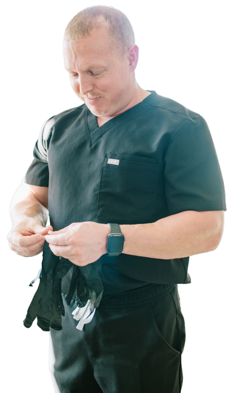 Man in dark uniform adjusting white gloves, standing against a white background.