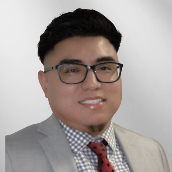 Man in gray suit, glasses, and red tie smiles at the camera.
