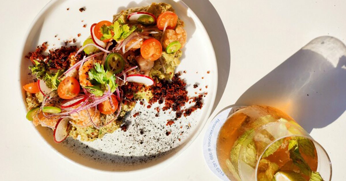 Un plato de comida y un vaso de agua sobre una mesa.