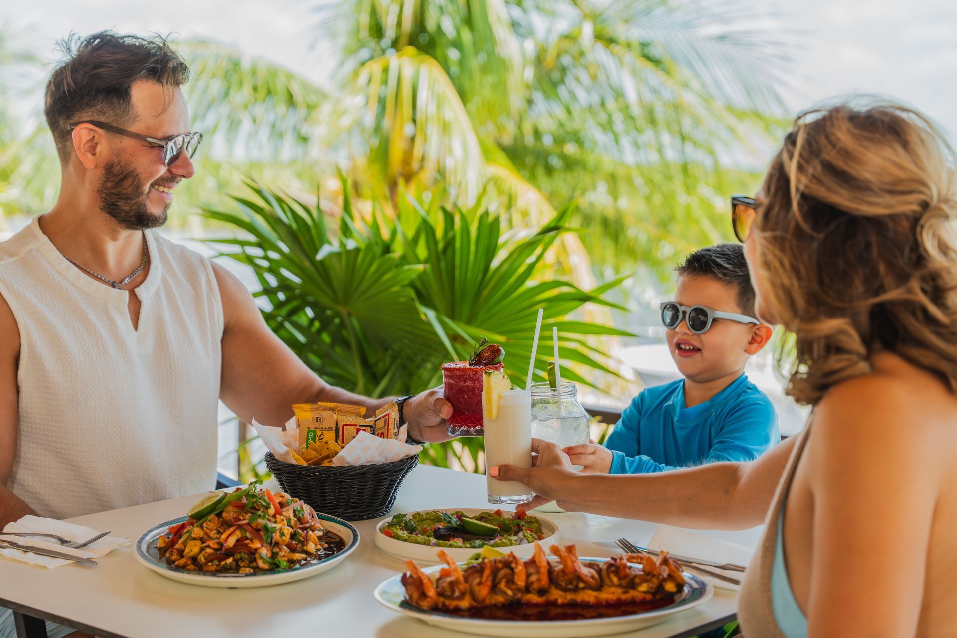 Un plato de comida y una bebida están en una mesa al lado de una piscina.