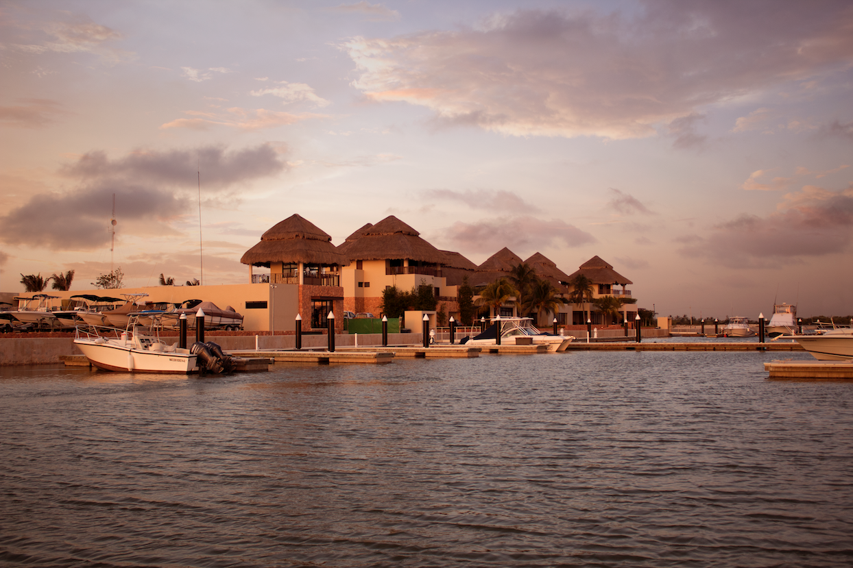 Un puerto deportivo con barcos atracados y un edificio al fondo.