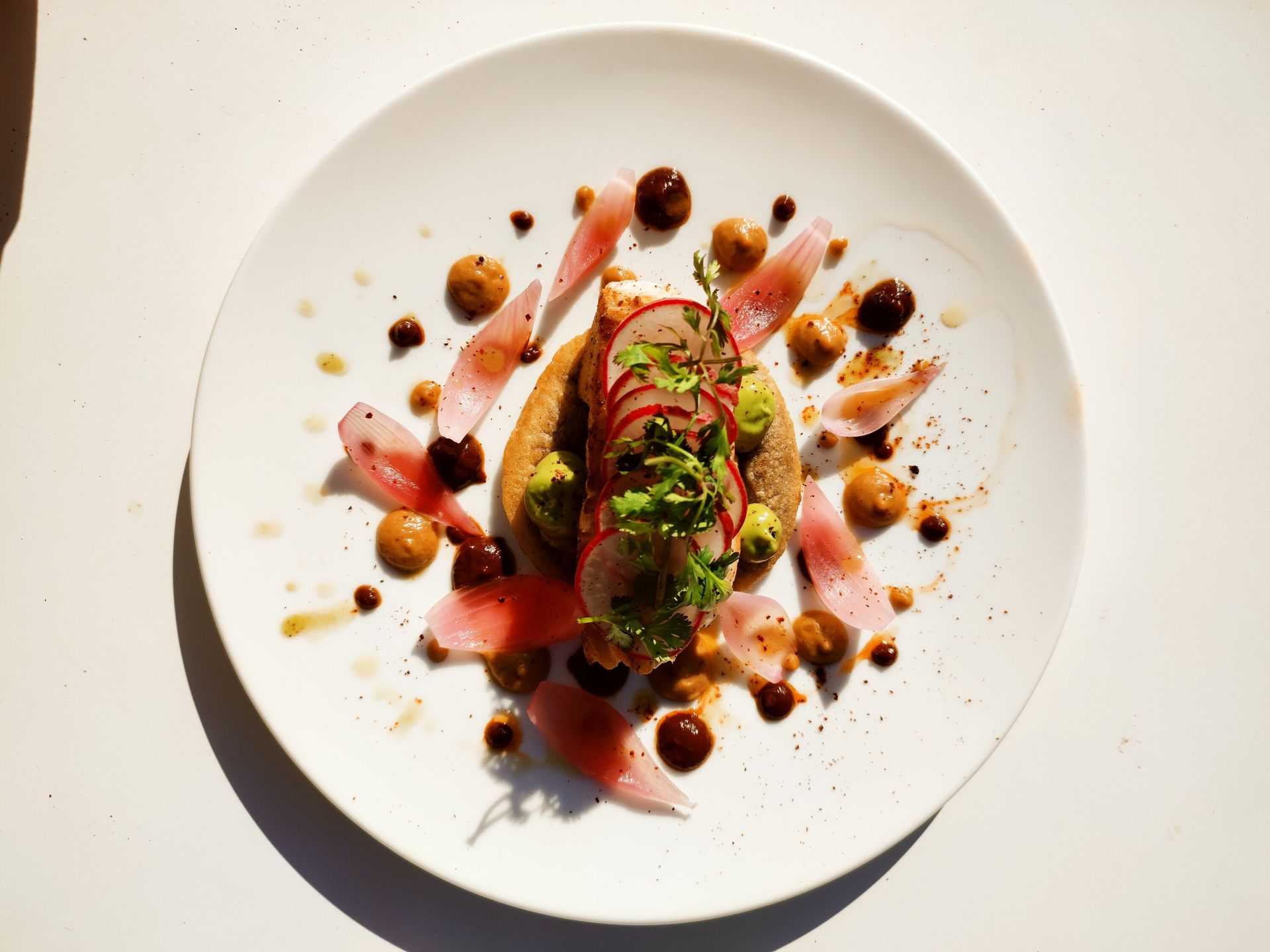 Un plato blanco cubierto con comida y nueces sobre una mesa.