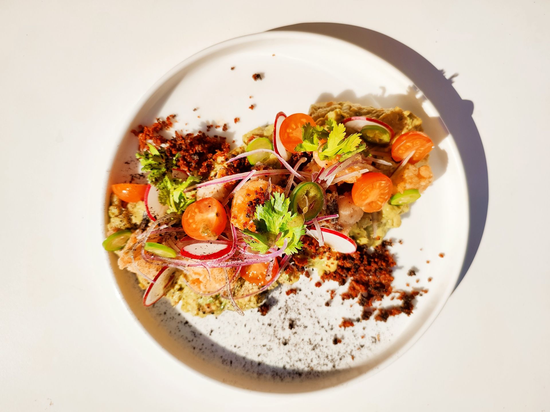 Un plato blanco cubierto con una ensalada de verduras y carne.