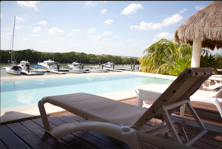 Una piscina con barcos atracados al fondo.