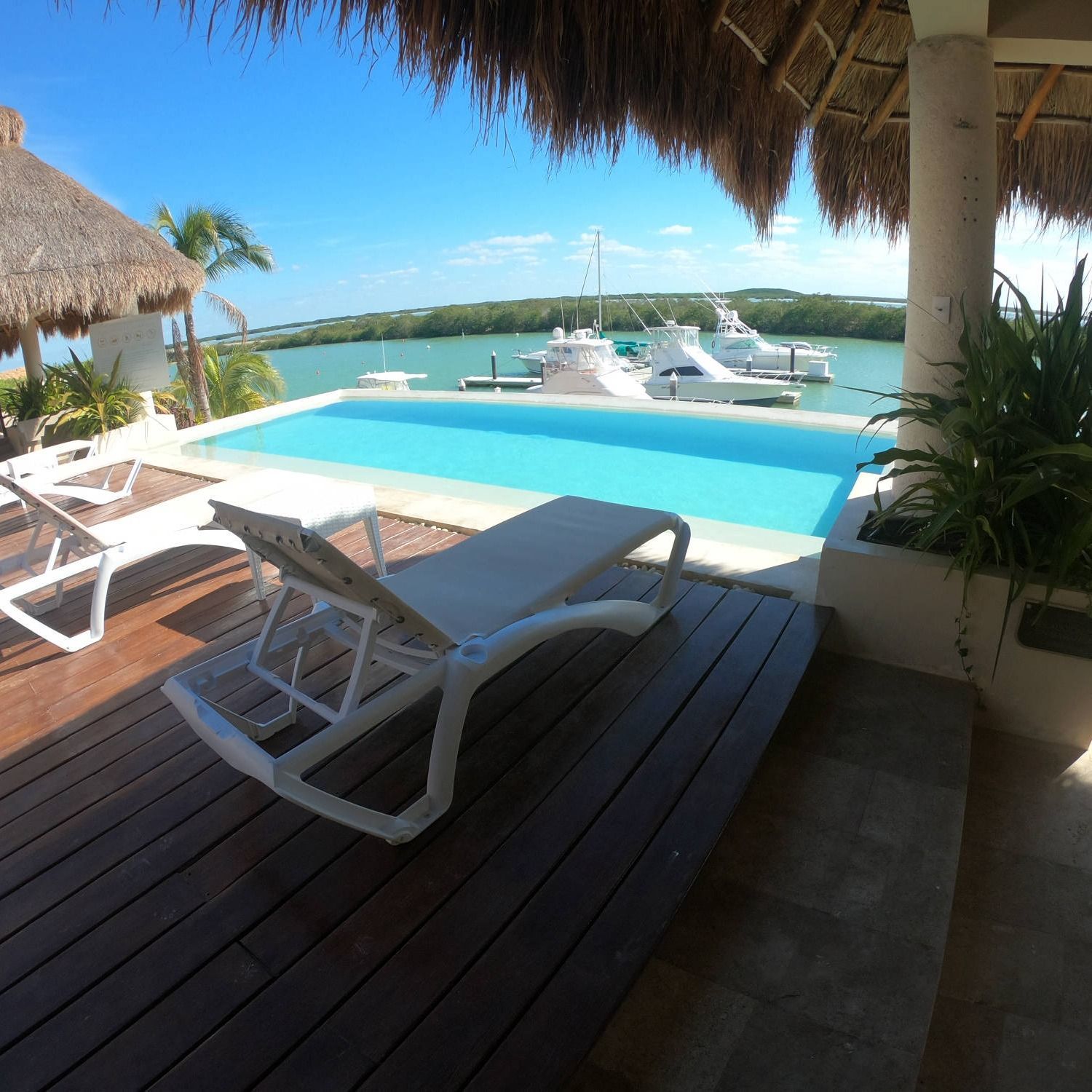 Una piscina con sillas y un barco al fondo.