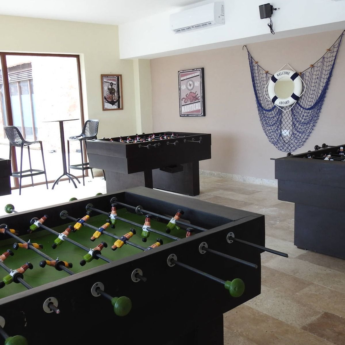 Una mesa de futbolín en una habitación con un salvavidas en la pared.