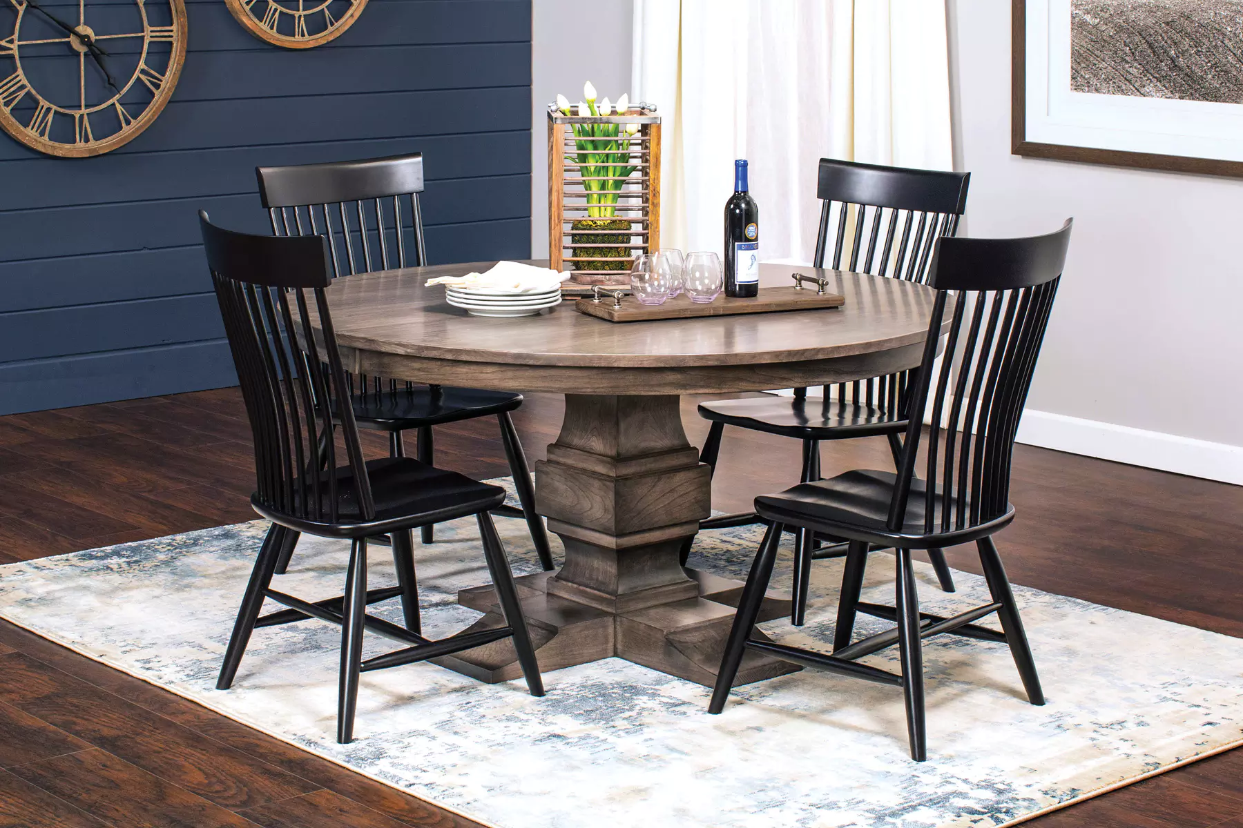 A dining room table and chairs with a bottle of wine on the table.