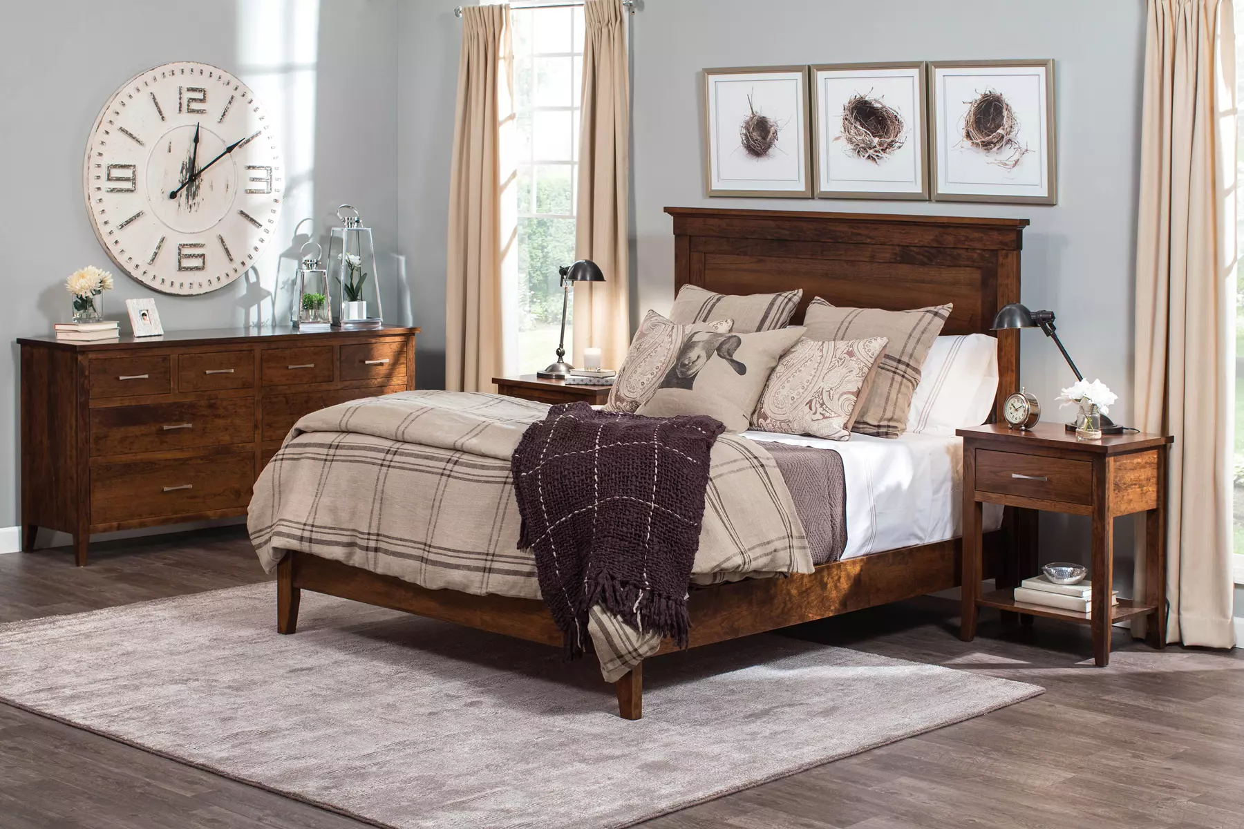 A bedroom with a bed , dresser , nightstand and a clock on the wall.