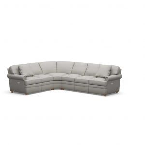 A grey sectional couch with pillows on a white background.