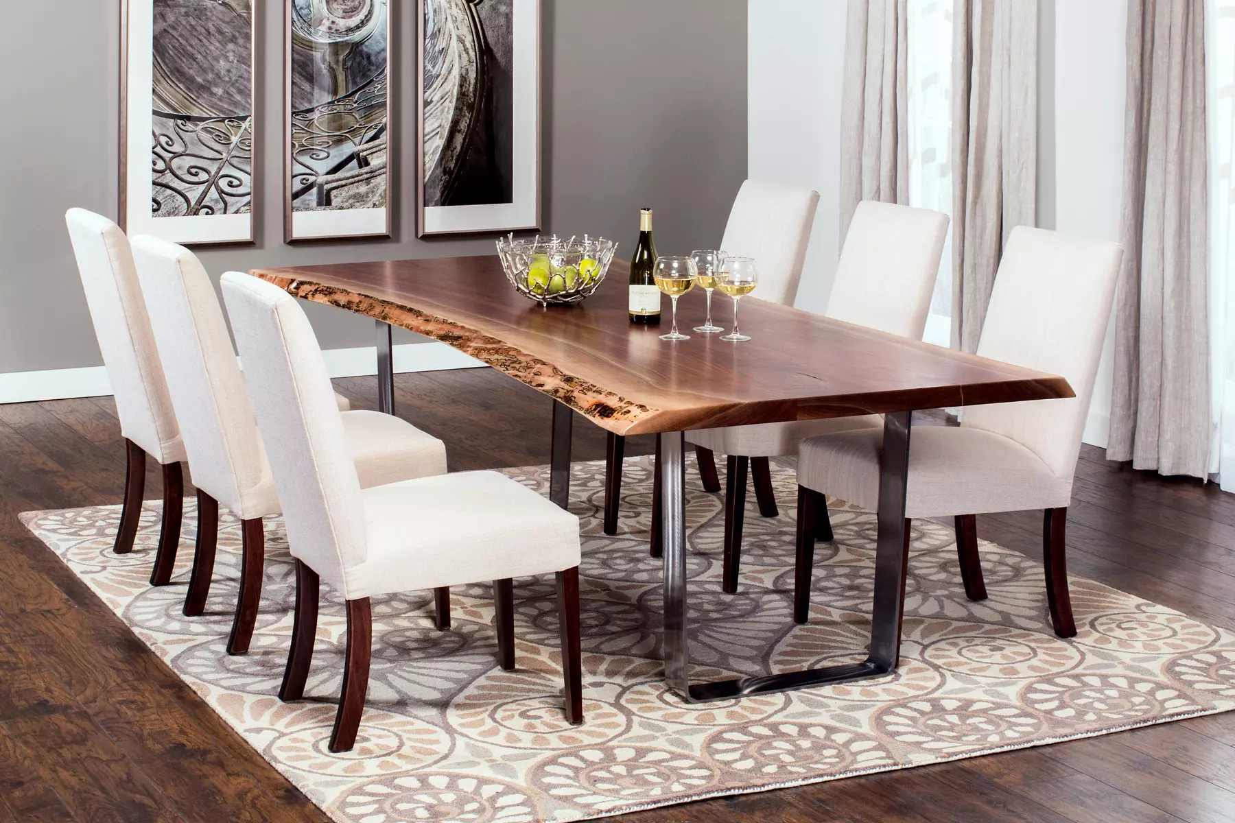 A dining room with a wooden table and white chairs.