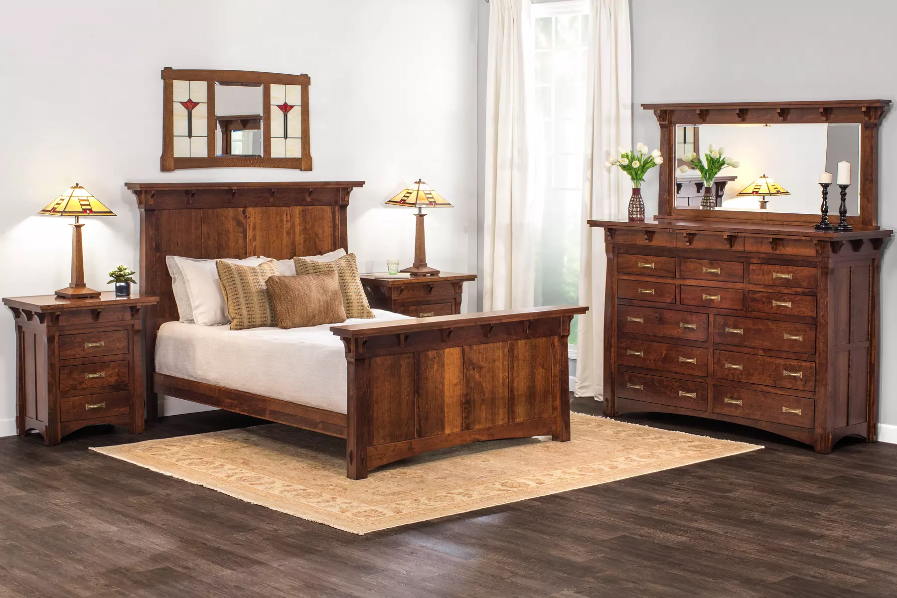 A bedroom with a bed , dresser , nightstand , mirror and rug.
