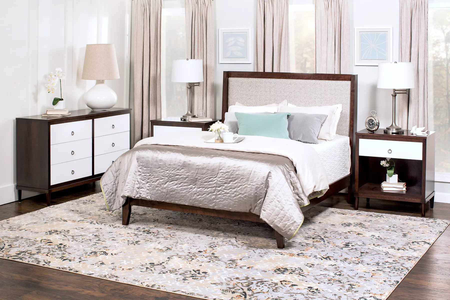 A bedroom with a bed , nightstand , dresser and rug.