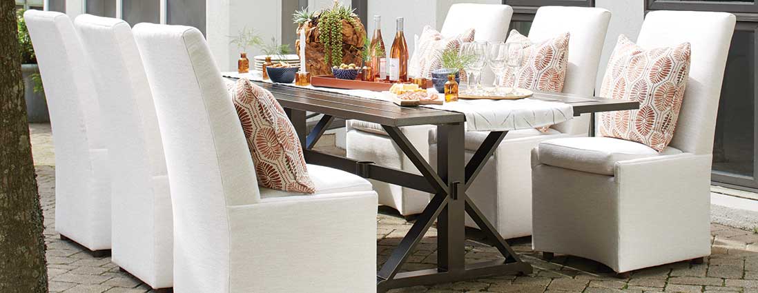 A dining table and chairs are sitting outside on a patio.