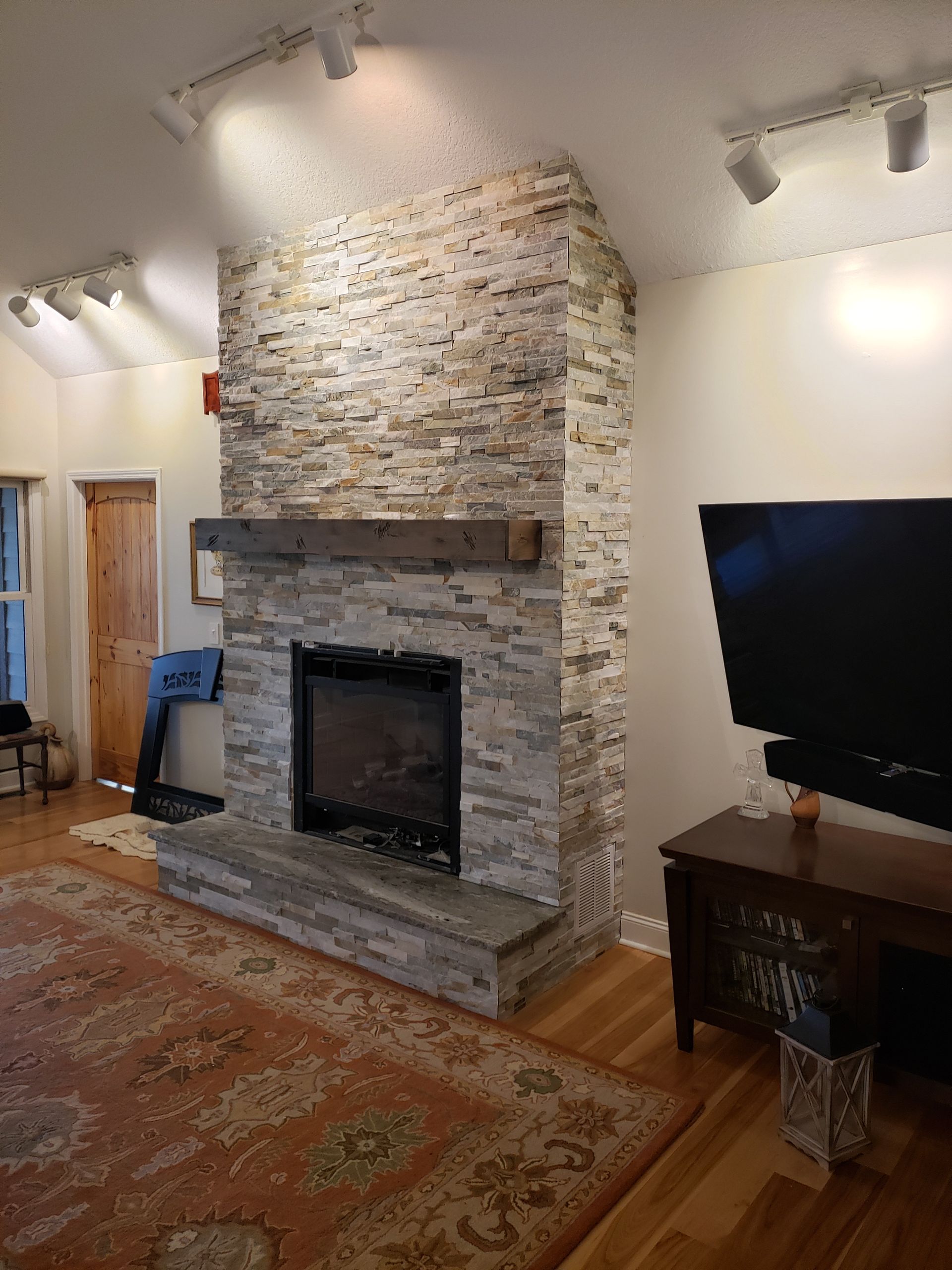 A living room with a fireplace and a flat screen tv.
