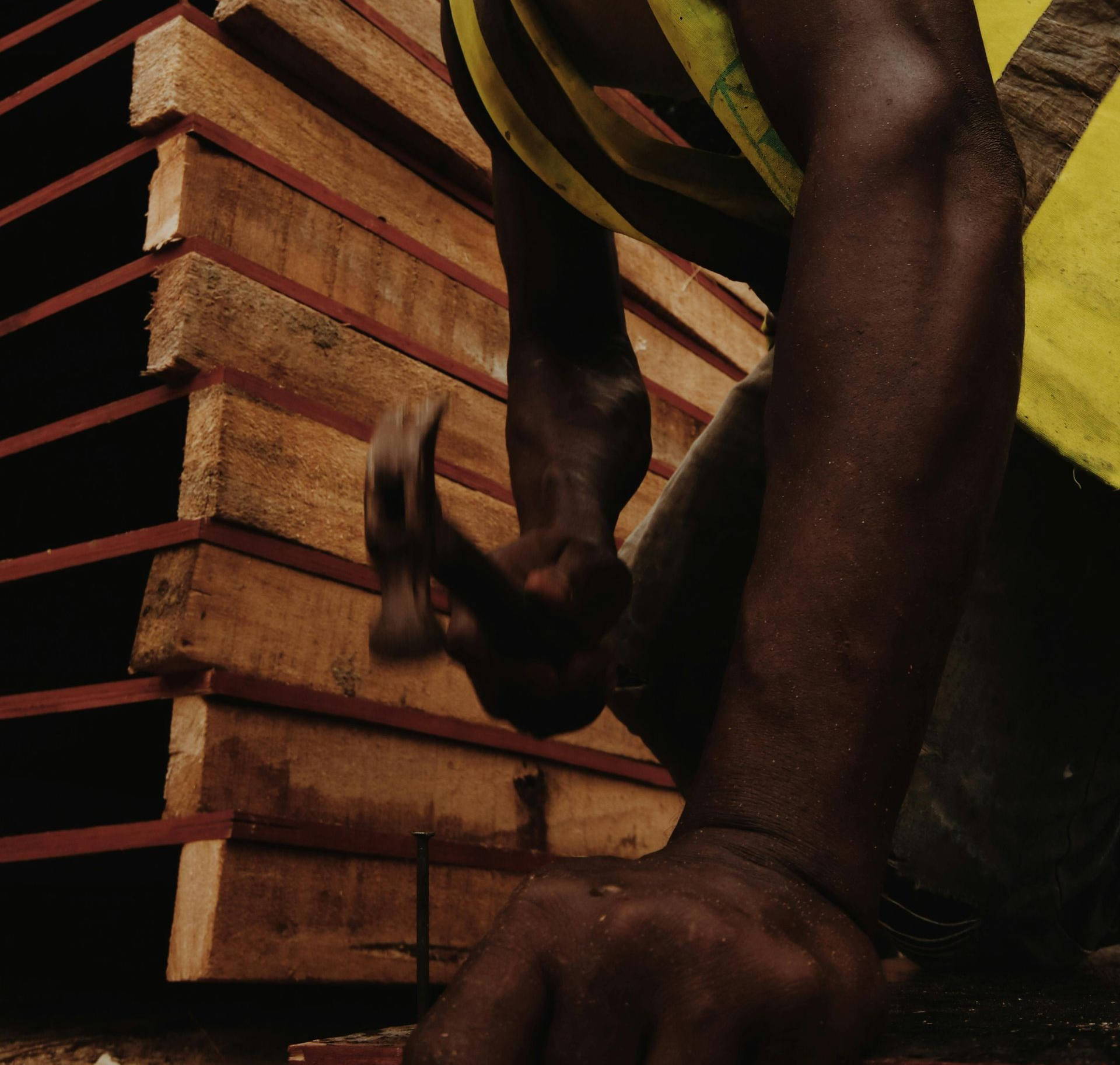 Person hammering wooden planks.