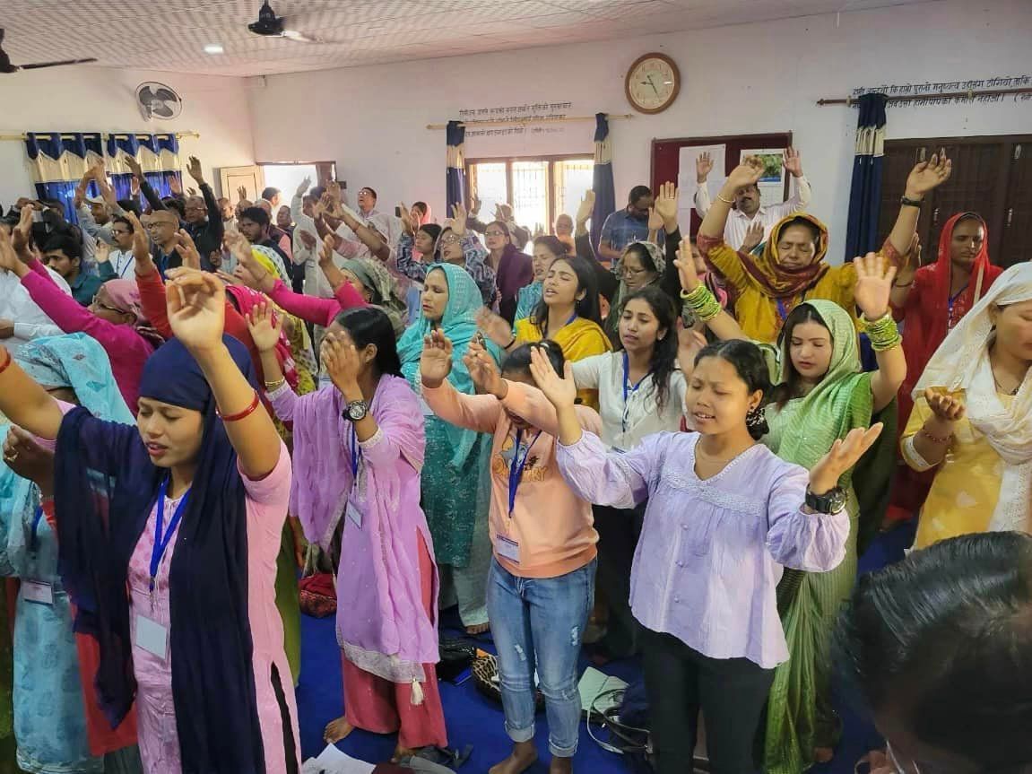 men and women worshipping; with their hands raised to God