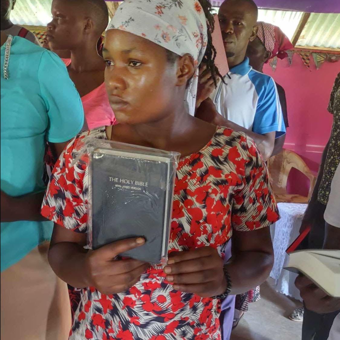 black lady in college sitting holding a bible up close with thanksgiving look on her face
